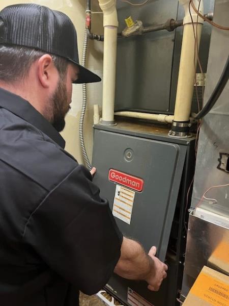 J and J Sheet Metal of Michigan technician inspecting and repairing a Goodman furnace in Battle Creek MI.