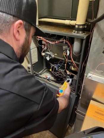 A J and J  technician on a furnace repair job in East Leroy MI.