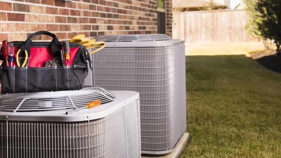 Two outdoor AC units with a toolbag sitting on top. J and J  will be happy to get your AC up and running again. Call (269) 965-1627 to schedule service.